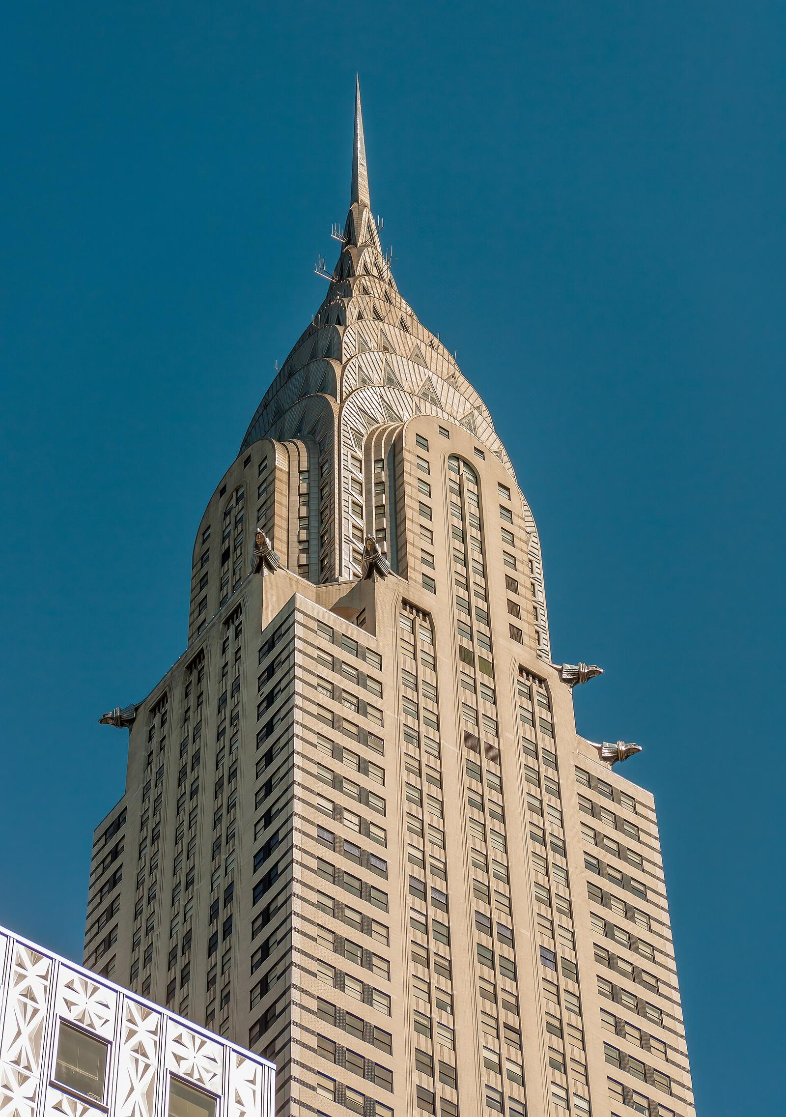 The Chrysler Building in New York, its terraced stainless-steel crown and eagle ornaments against a clear blue sky