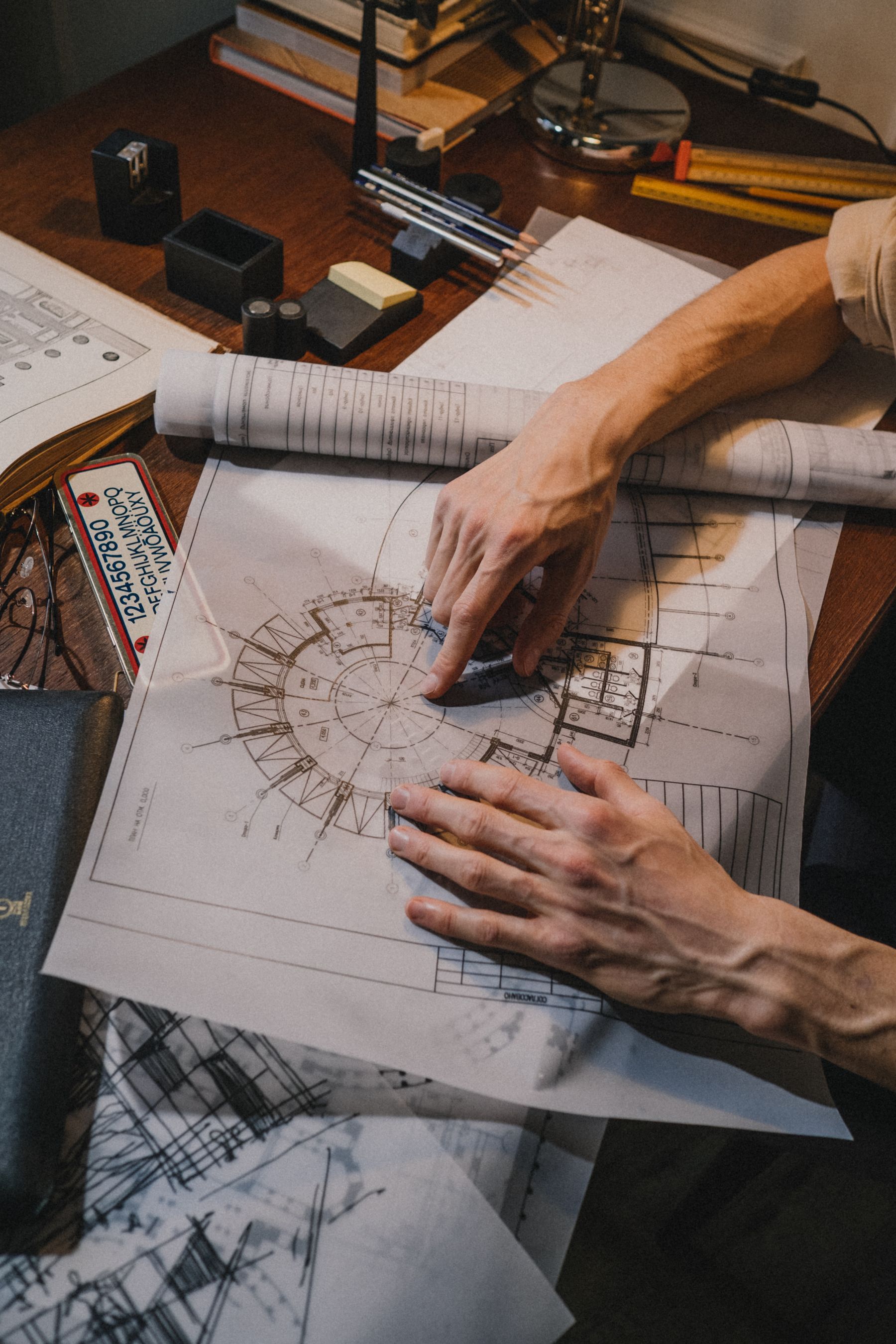 Architect checking a detailed circular plan across printed drawing sheets