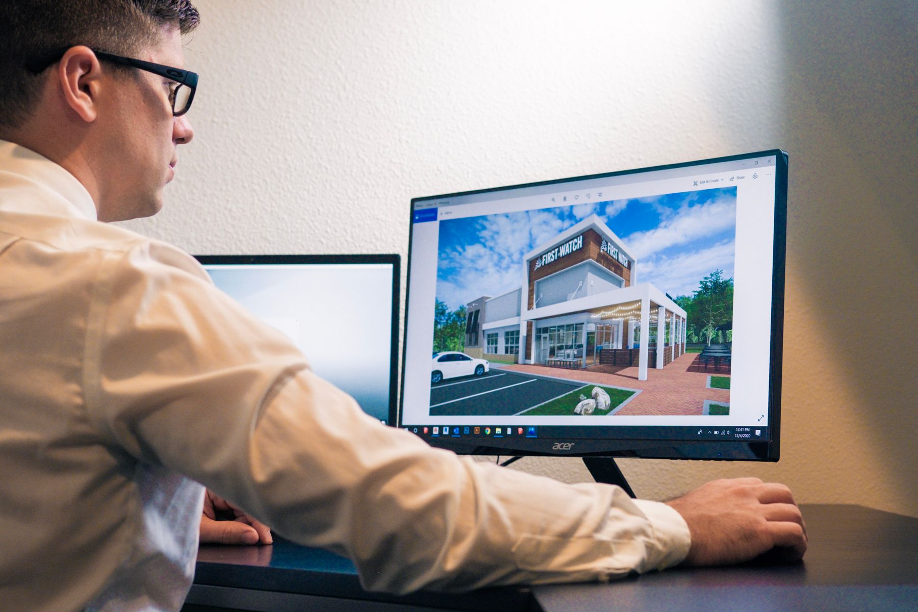 Architect reviewing a digital building visualisation on a desktop workstation