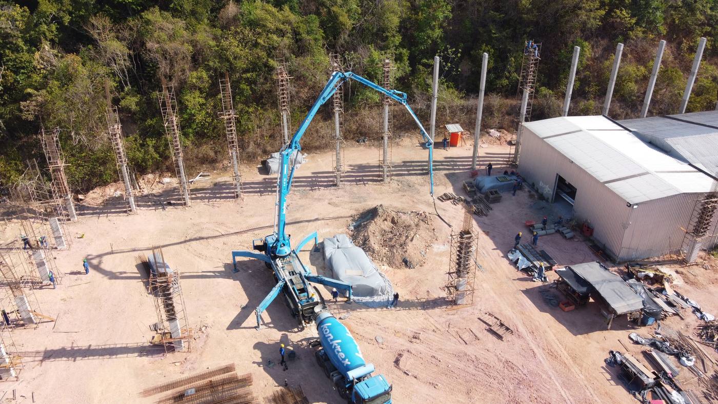 A concrete boom pump truck pouring in-situ concrete on a construction site in Manaus, Brazil