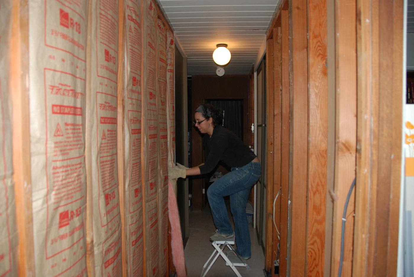A worker installing wall insulation