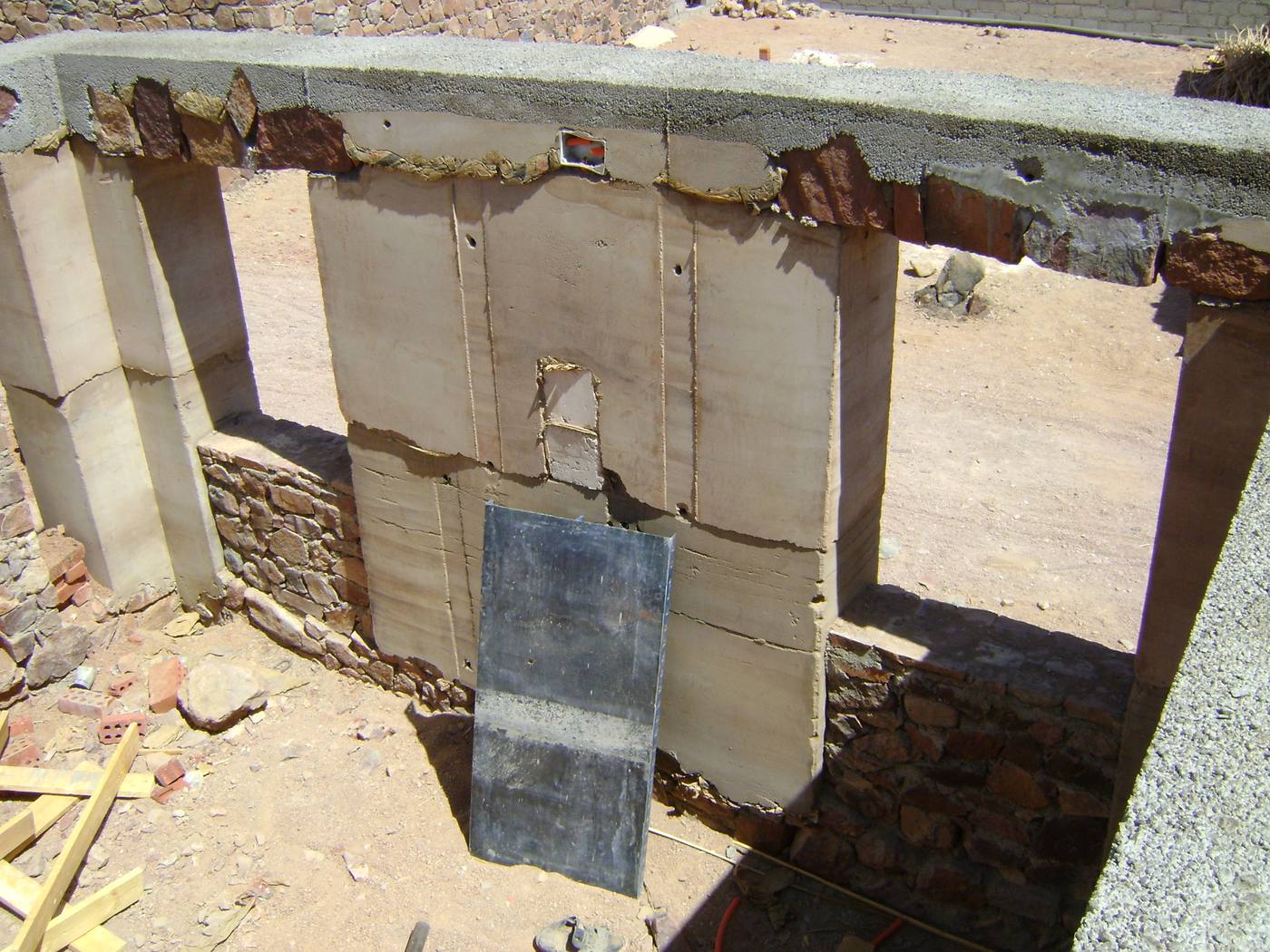 A rammed earth wall under construction, showing the layered formwork panels