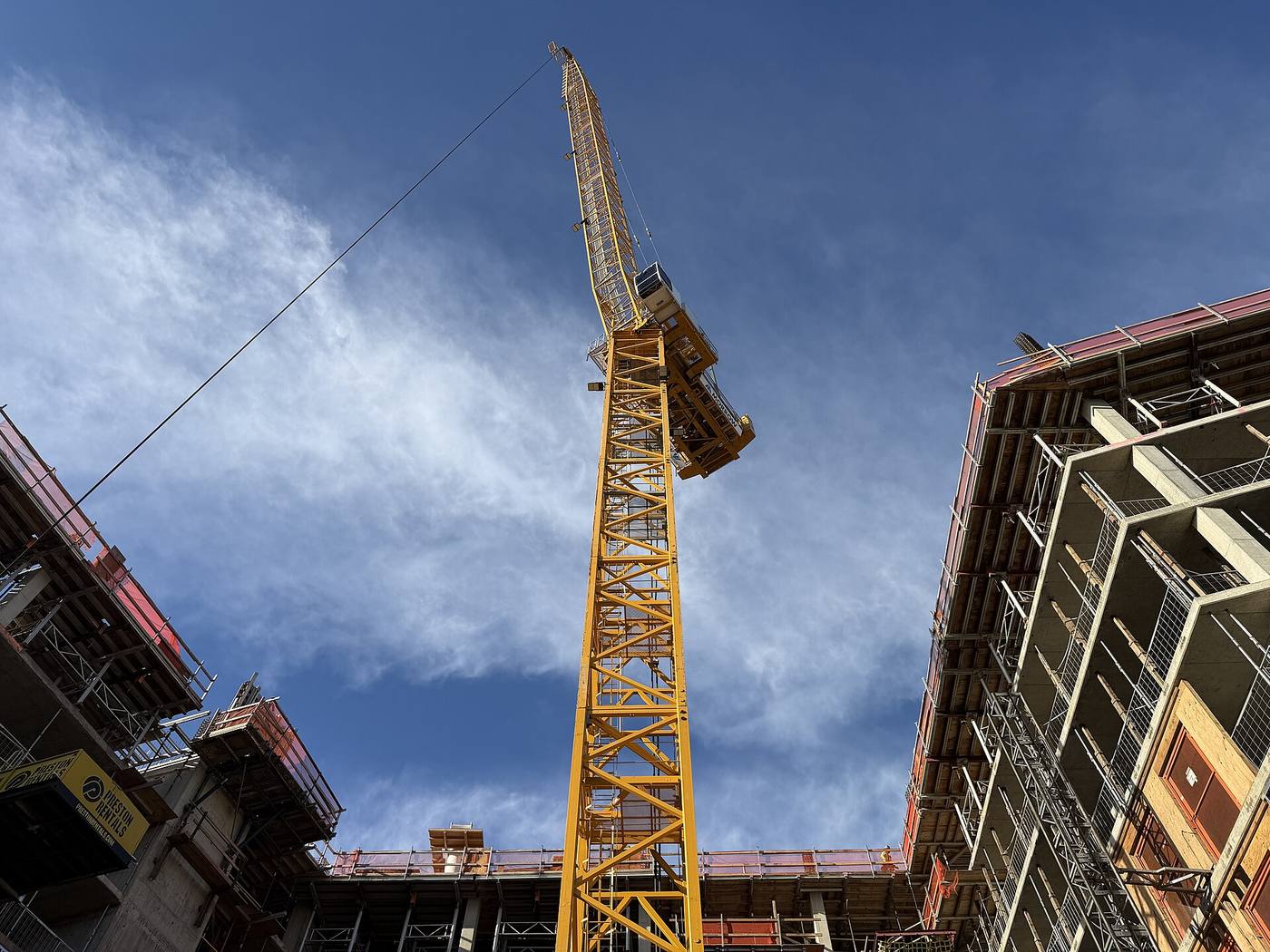 A tower crane over a concrete-frame building under construction