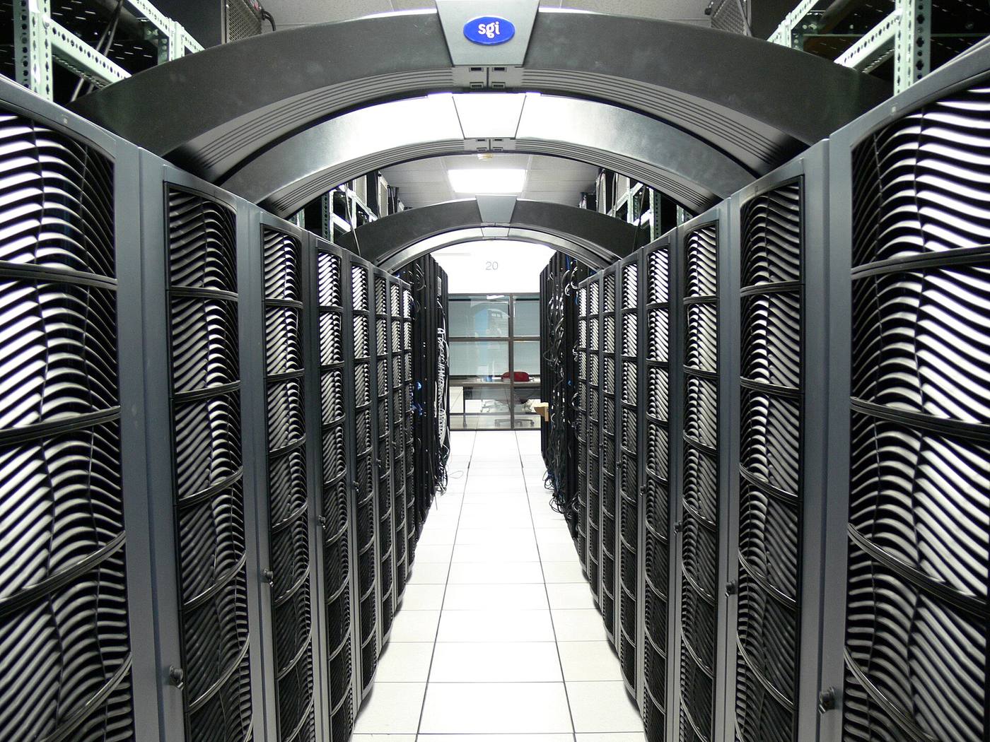 Arched rows of server racks forming a dramatic corridor in a data centre