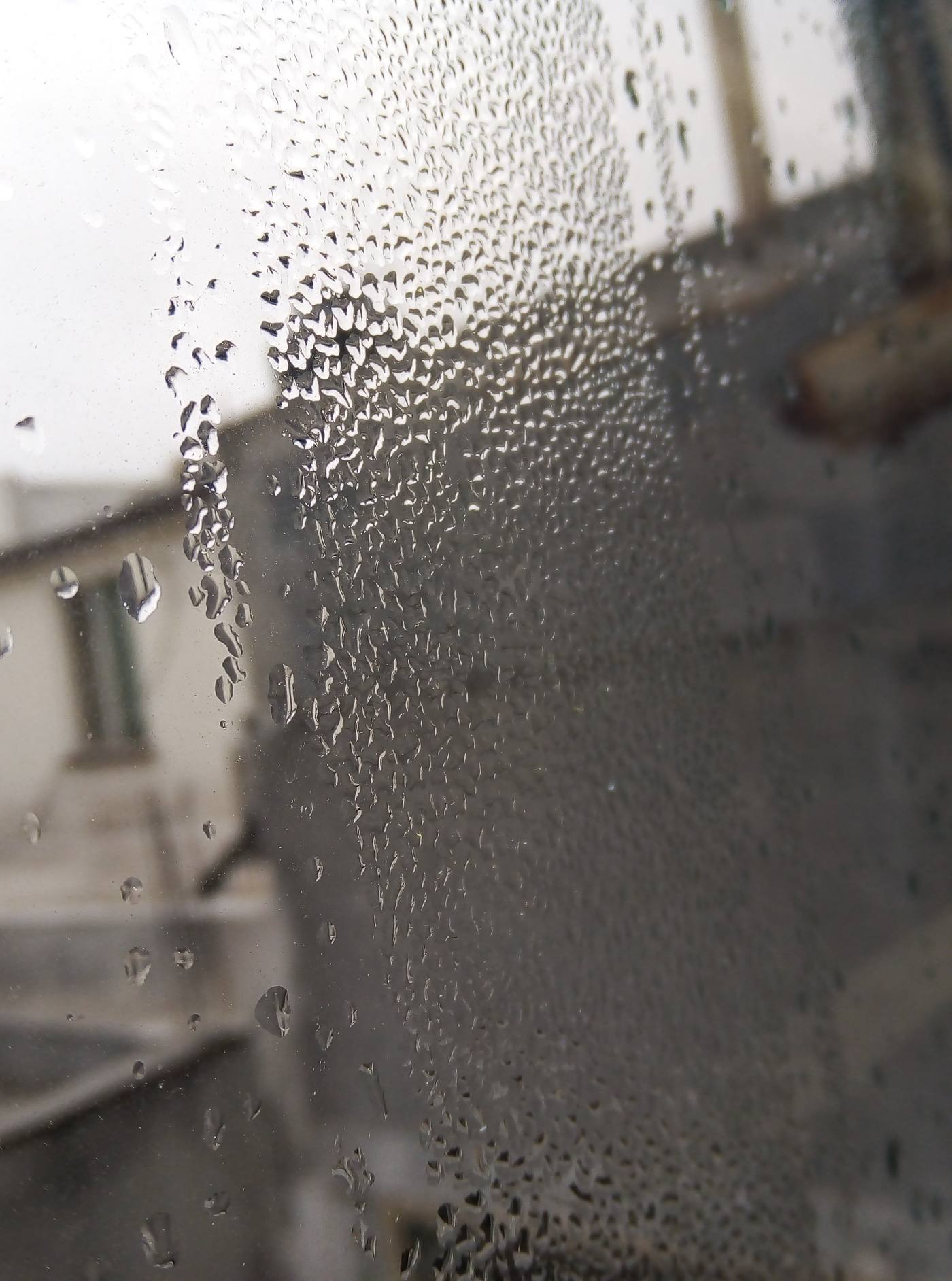 A window streaming with condensation on a cold morning — the dew point made visible