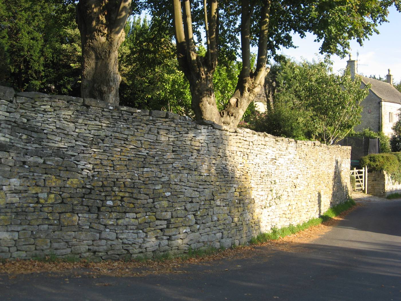 A Cotswold dry-stone wall — traditional craft and local material in a listed setting