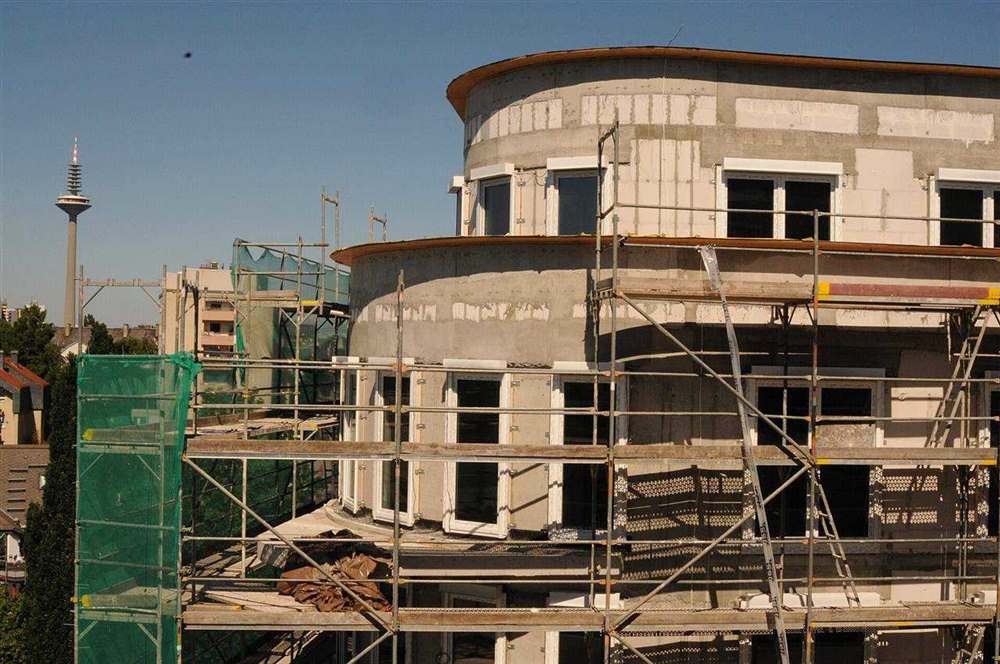 Construction-stage view of a passive house in Frankfurt showing the unfinished building envelope