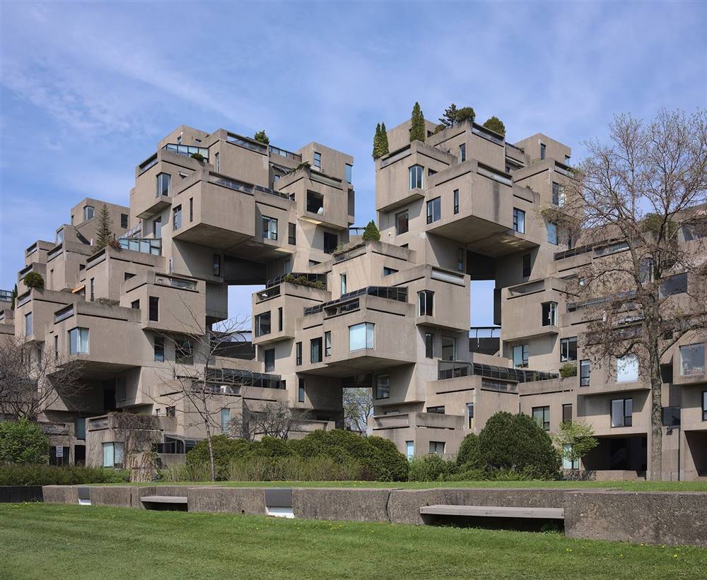 Ground-level view of Habitat 67 in Montreal showing stacked precast concrete housing units and terraces