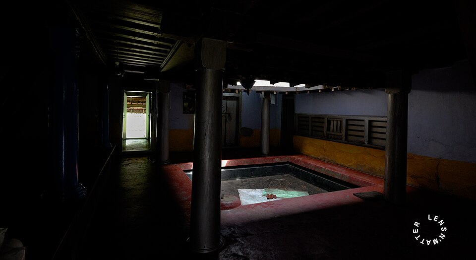 Traditional nadumuttam courtyard in a Kerala house with shaded timber edges