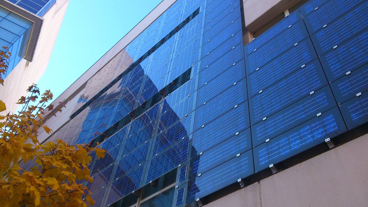 Photovoltaic panels mounted onto an existing building facade as a bolt-on applied system