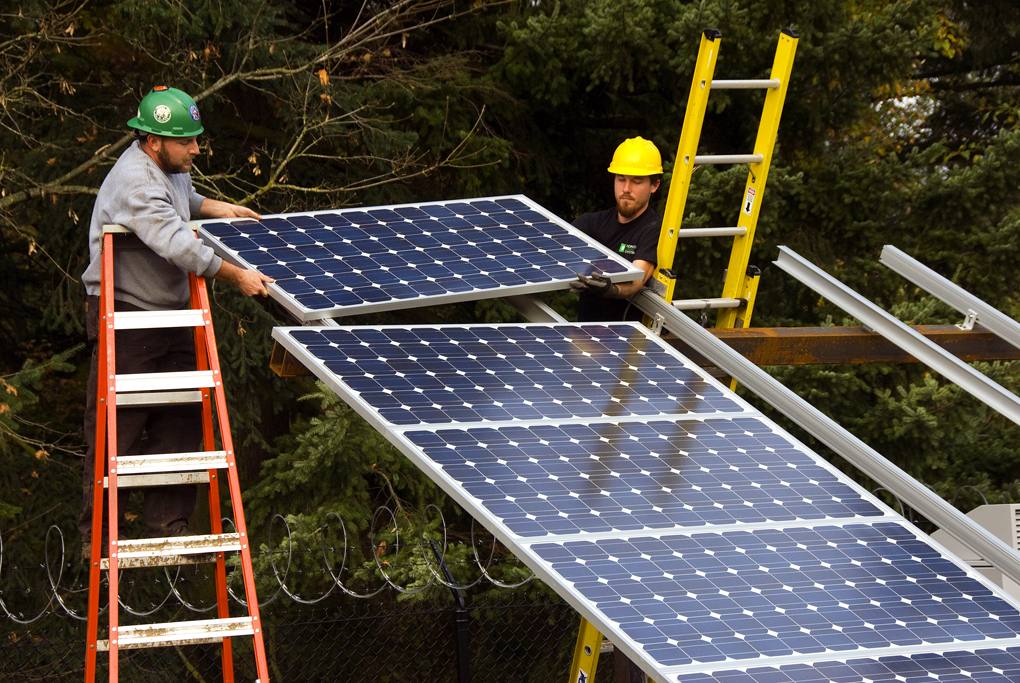 Installers fitting photovoltaic modules during a solar array installation