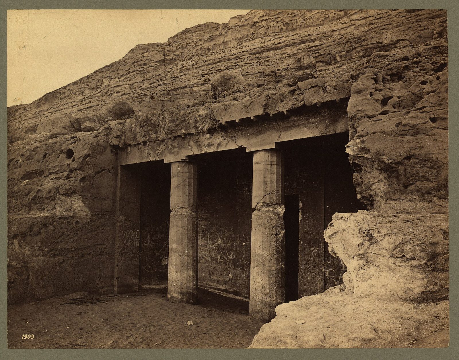 The portico of a rock tomb at Beni Hasan in a nineteenth-century photograph: two fluted columns, the so-called proto-Doric order, before the tomb entrance