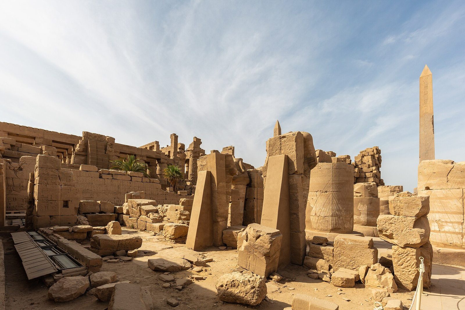 The central court of Karnak: broken columns and festival-hall walls around the standing obelisk of Thutmose I