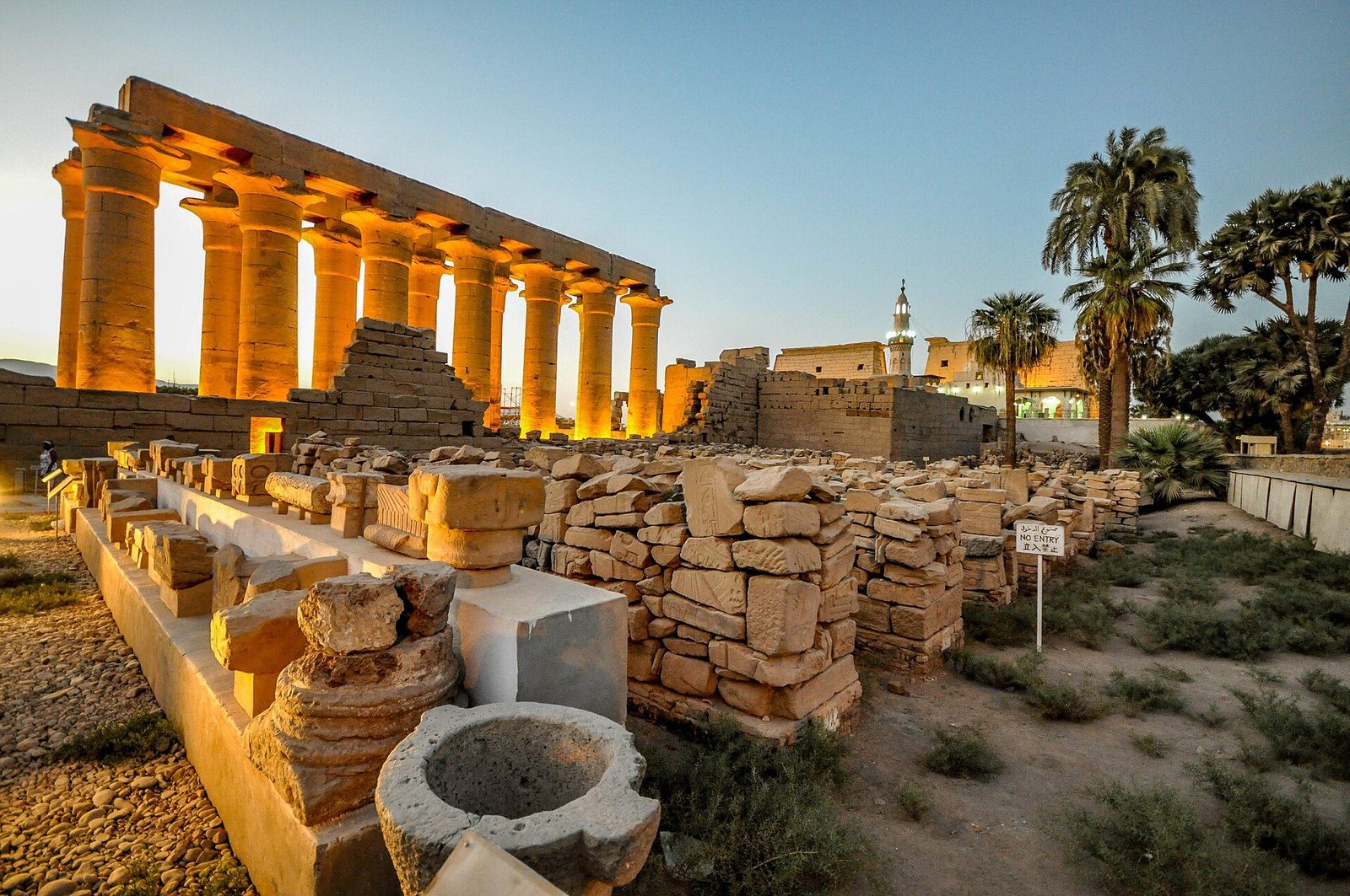 The colonnade of Amenhotep III at Luxor Temple: papyrus-bundle columns lit by evening sun across the peristyle court
