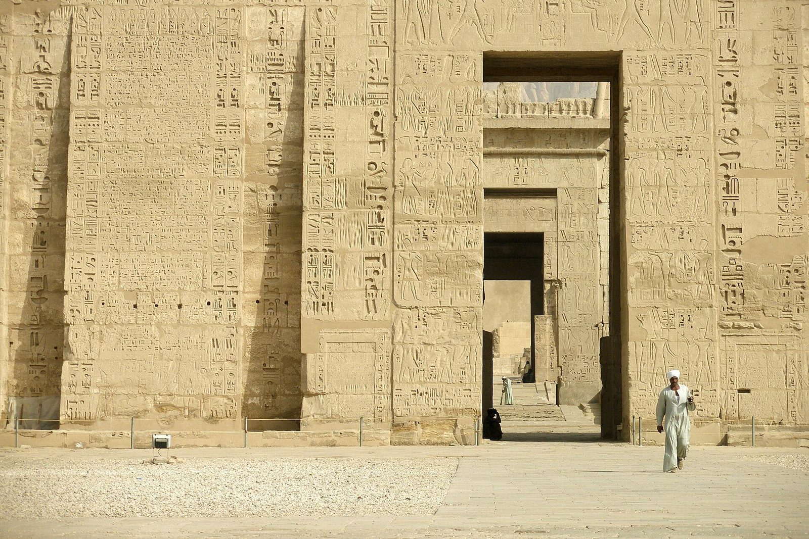 The first pylon of the mortuary temple of Ramesses III at Medinet Habu: its face carved with the king's victories and pierced by tall flagstaff slots