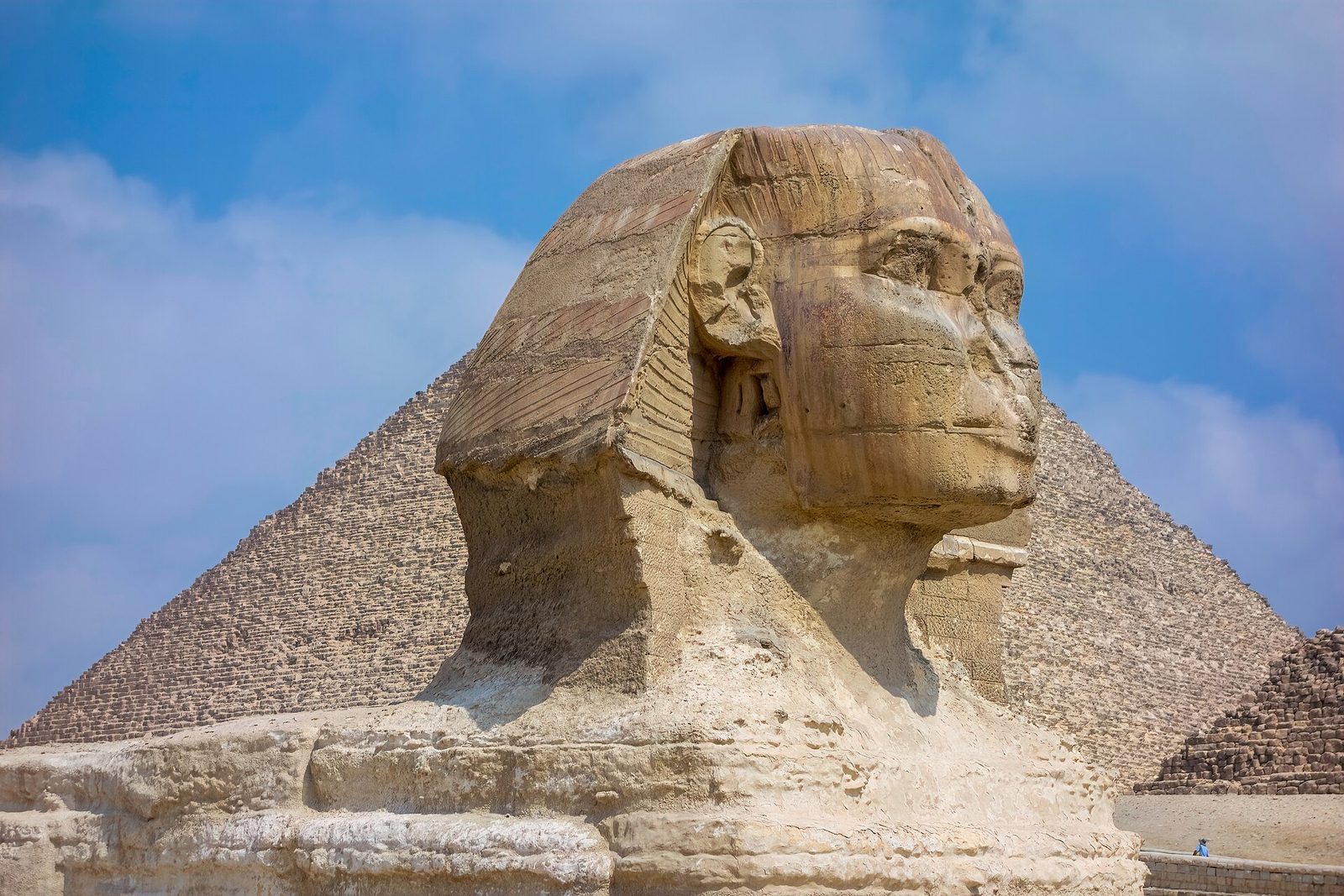The Great Sphinx of Giza in profile, the pyramid of Khafre behind: a king's head on a lion's body cut from a single ridge of bedrock