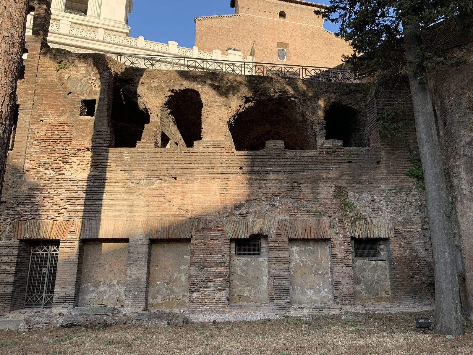 The brick facade of the Insula dell'Ara Coeli in Rome: ground-floor shop doorways below the arched openings of the upper apartments, at the foot of the Capitoline Hill