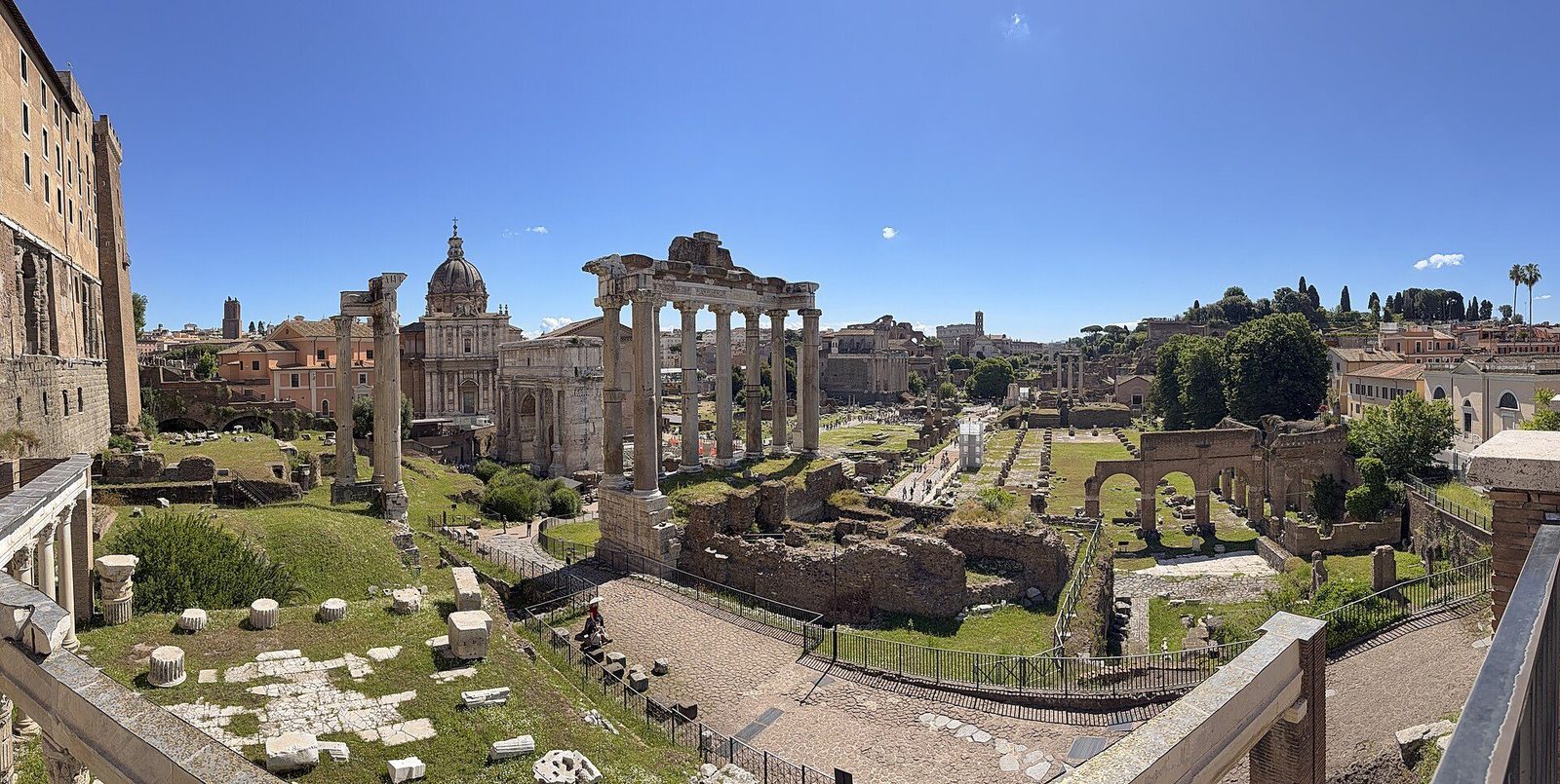The Roman Forum from its east end: the tall columns of the Temple of Saturn above a spread of ruins along the Via Sacra