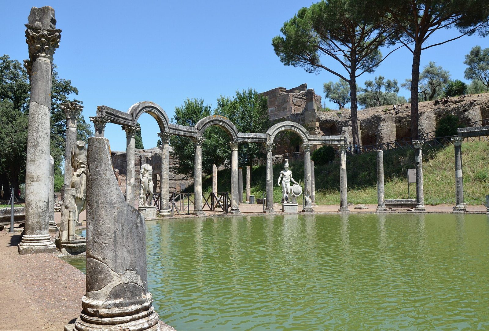 The Canopus at Hadrian's Villa, Tivoli: the long reflecting pool framed by statues and broken columns, with the arched pergola at its far end