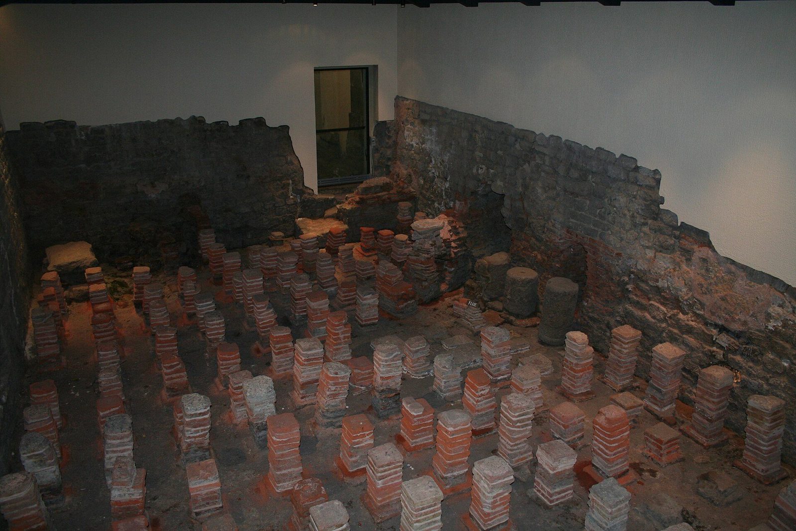 A Roman hypocaust preserved at the Roman Baths in Bath, England: rows of short tile stacks (pilae) that once carried the heated floor above