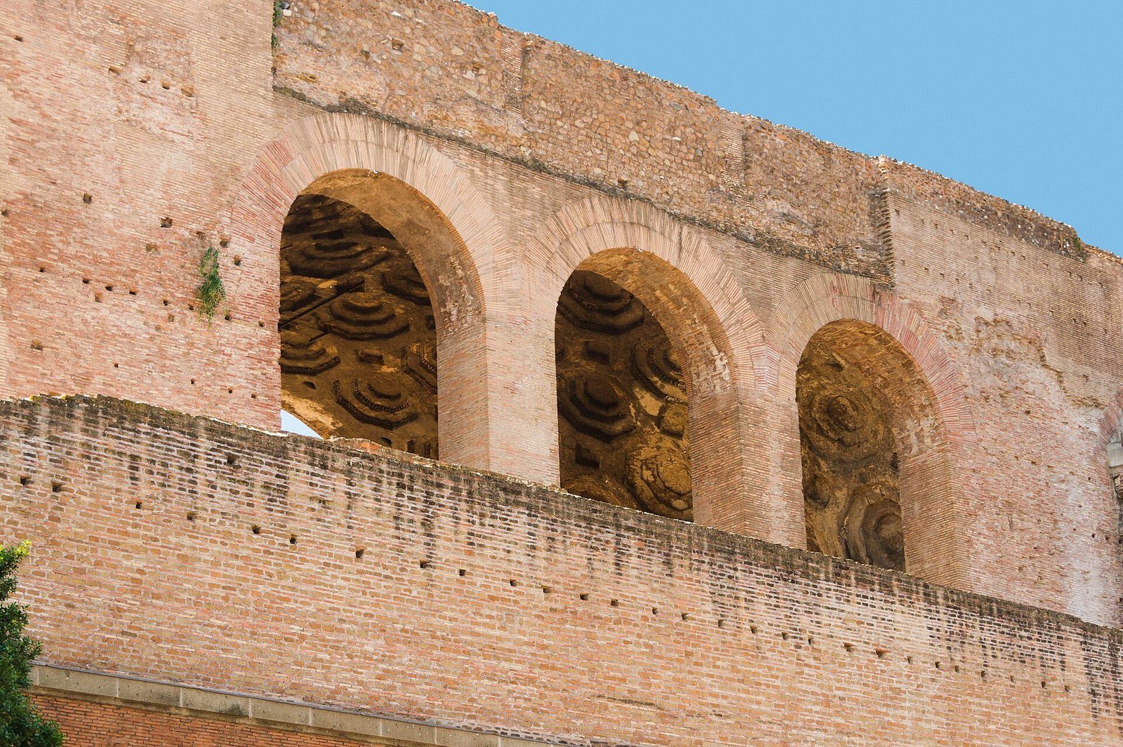 The Basilica of Maxentius in the Roman Forum: three enormous arched openings into its nave, the coffered concrete vaults visible within