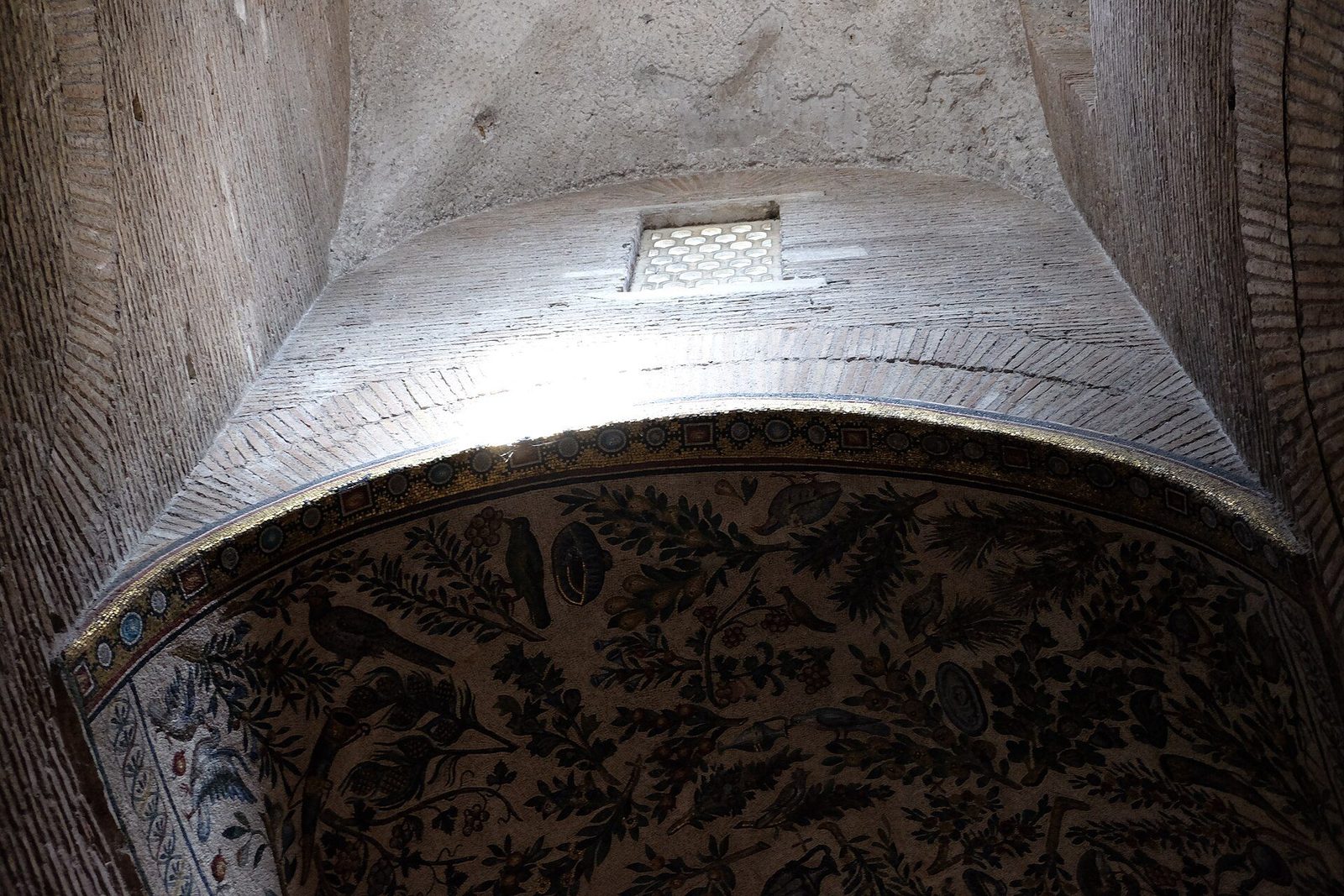 Inside Santa Costanza in Rome: a barrel-vaulted bay of the circular ambulatory, with part of its early Christian vine-scroll mosaic below