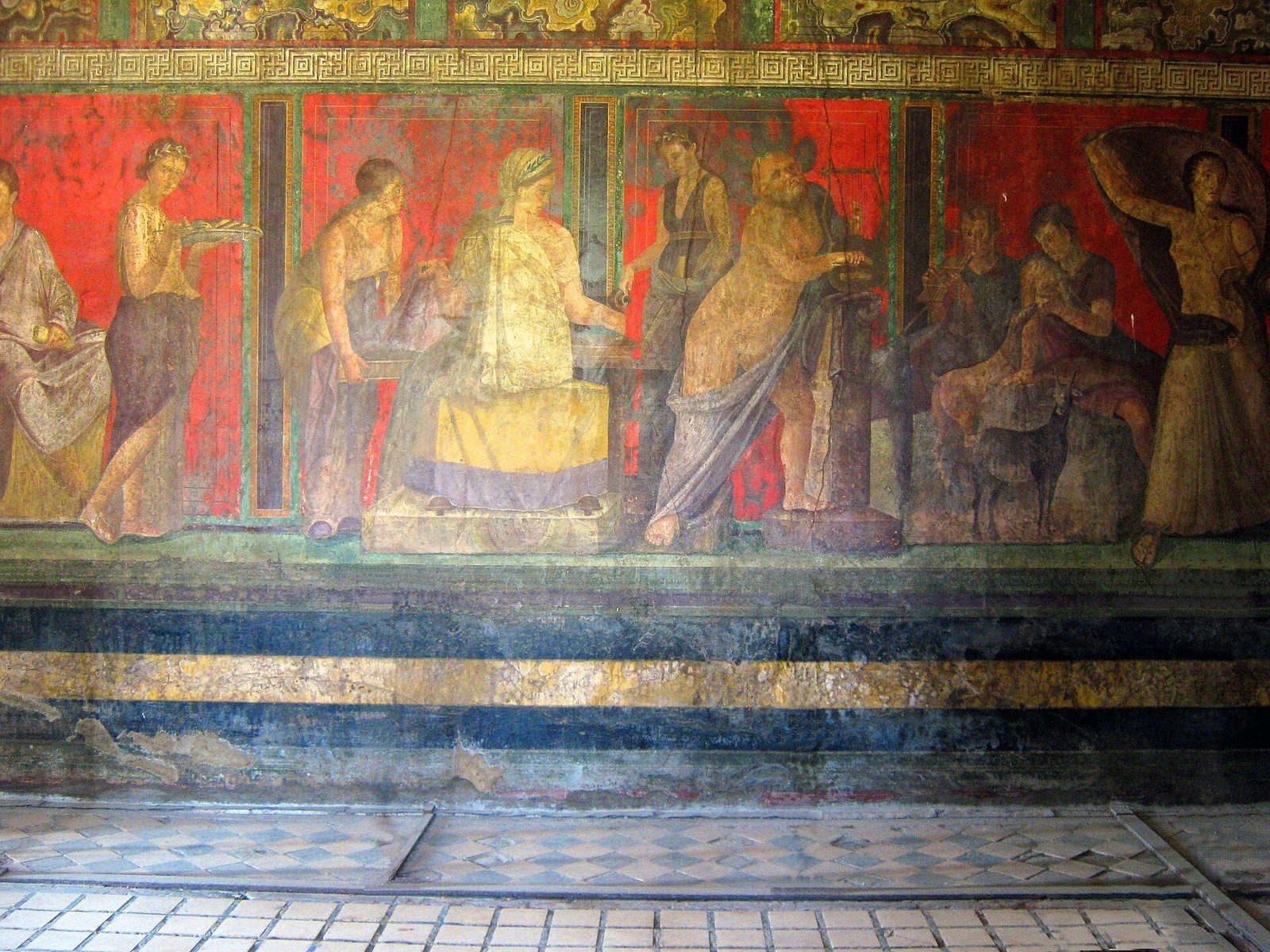 The Dionysiac frieze of the Villa of the Mysteries at Pompeii: life-size painted figures against a deep red wall above a mosaic floor
