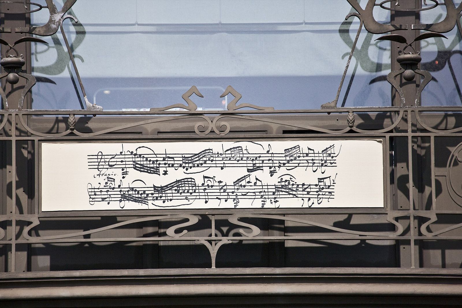 Detail of the Old England building in Brussels: a sheet-music frieze set in curling ironwork