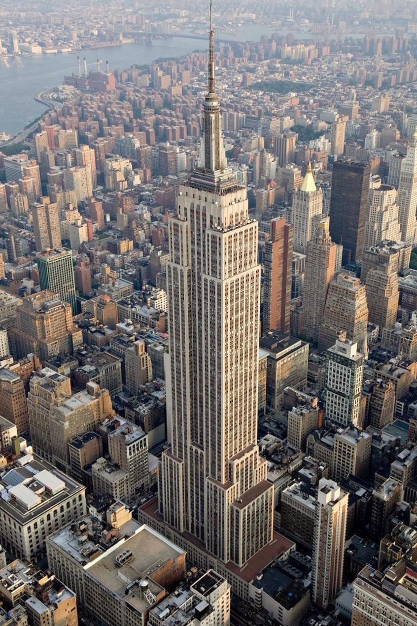 The Empire State Building from the air, its setback shaft and mooring mast above Manhattan