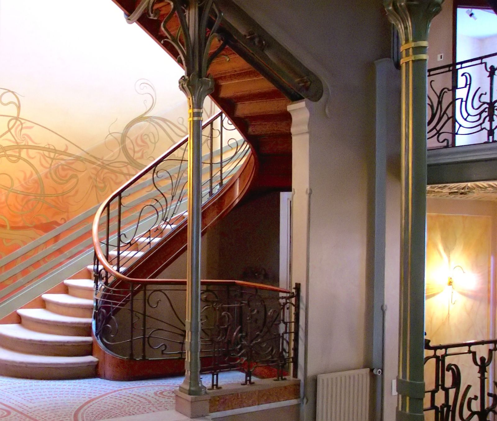 The staircase of the Hôtel Tassel in Brussels, its iron railing curling in the whiplash line under a glazed dome