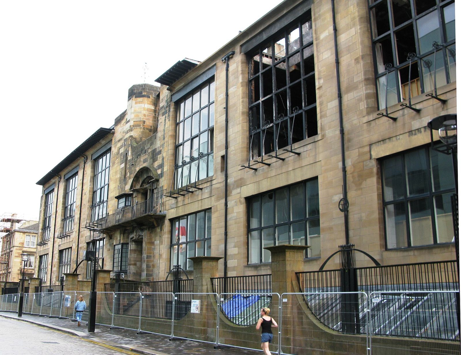 The north facade of the Glasgow School of Art, its great studio windows boarded after the fires of 2014 and 2018