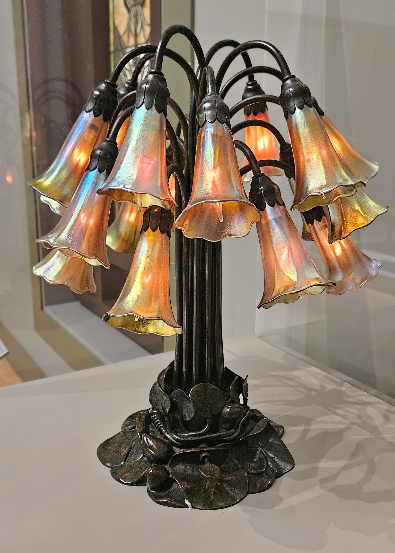 An eighteen-light lily lamp by Tiffany Studios, its favrile glass shades opening like flowers