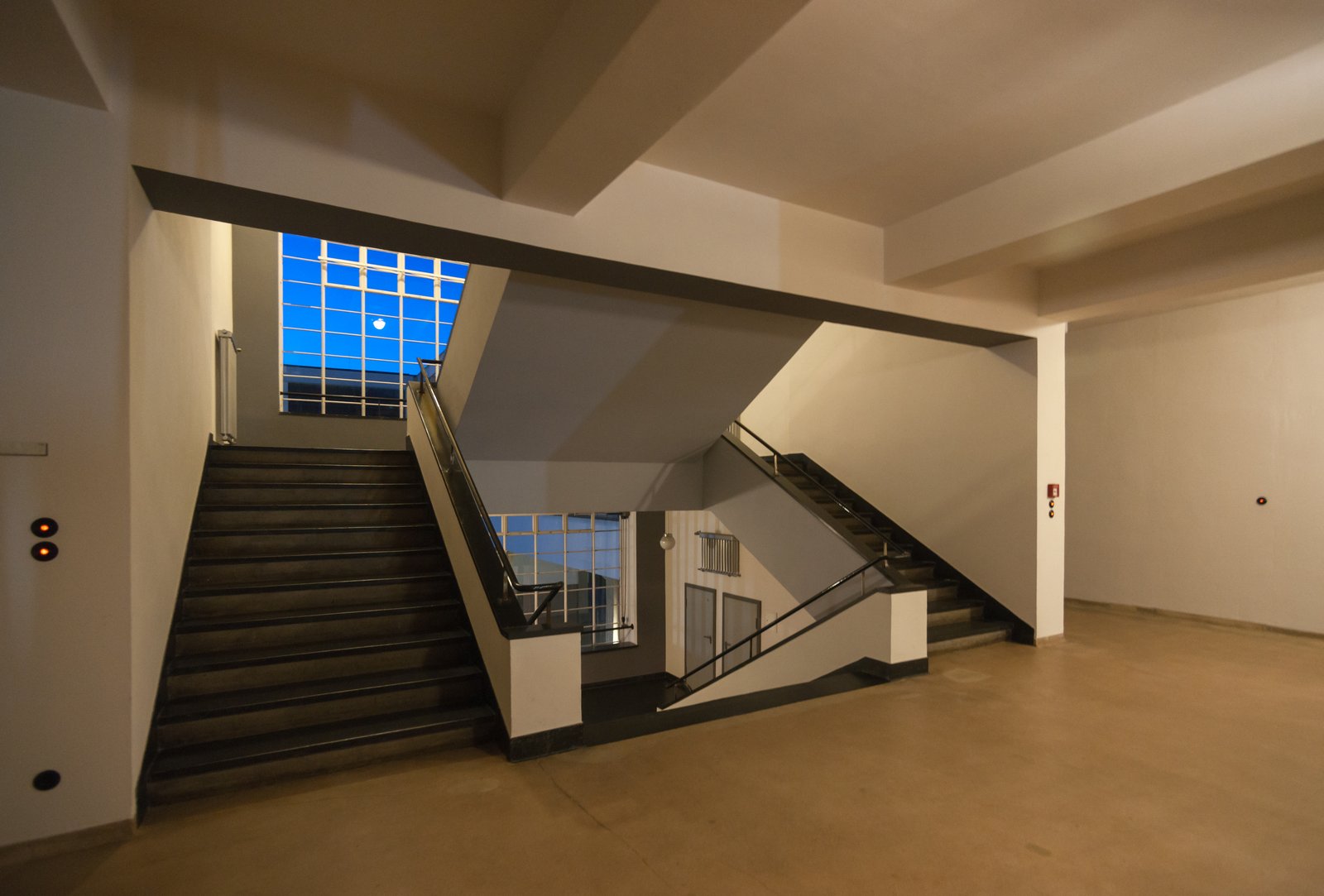 A staircase inside the Bauhaus building in Dessau with a steel balustrade