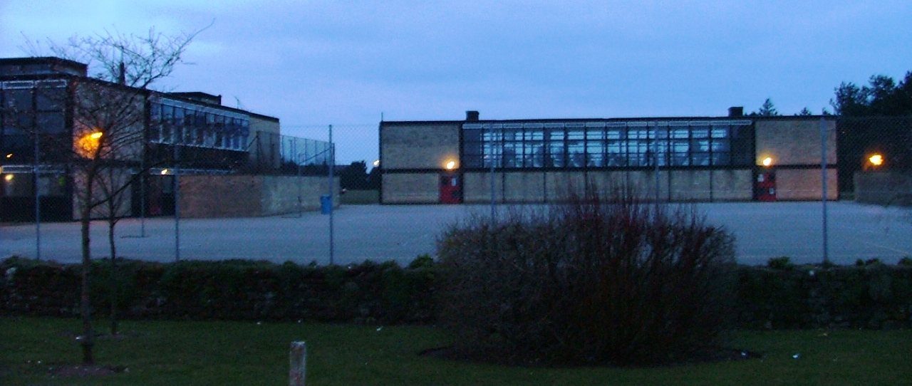 Smithdon High School, Hunstanton, at dusk — the glass hall and gymnasium block