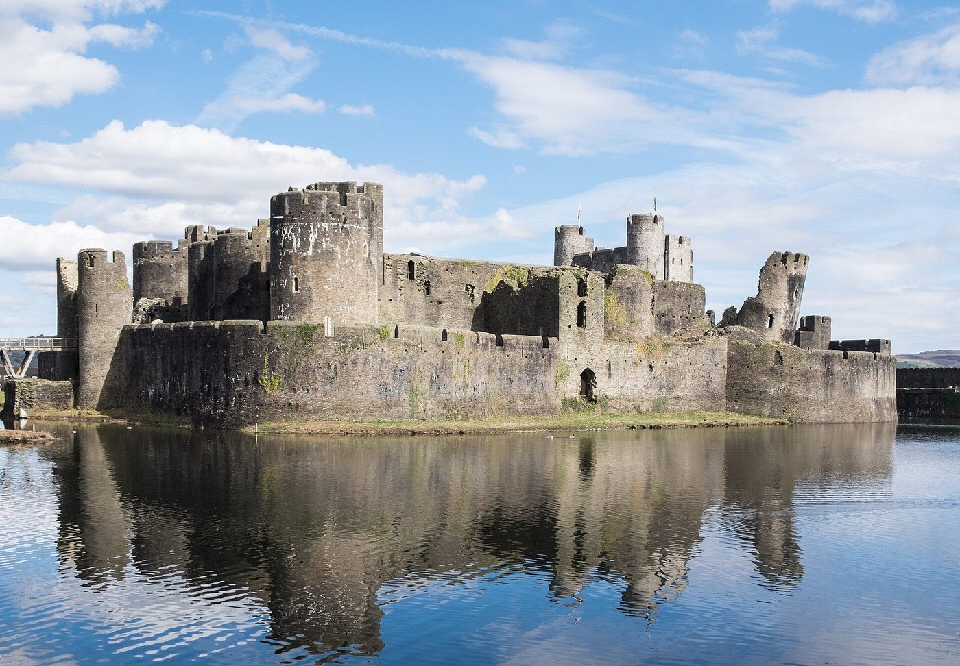 Caerphilly Castle from the south: towers and gatehouses rising from the artificial lake, the leaning tower at its corner