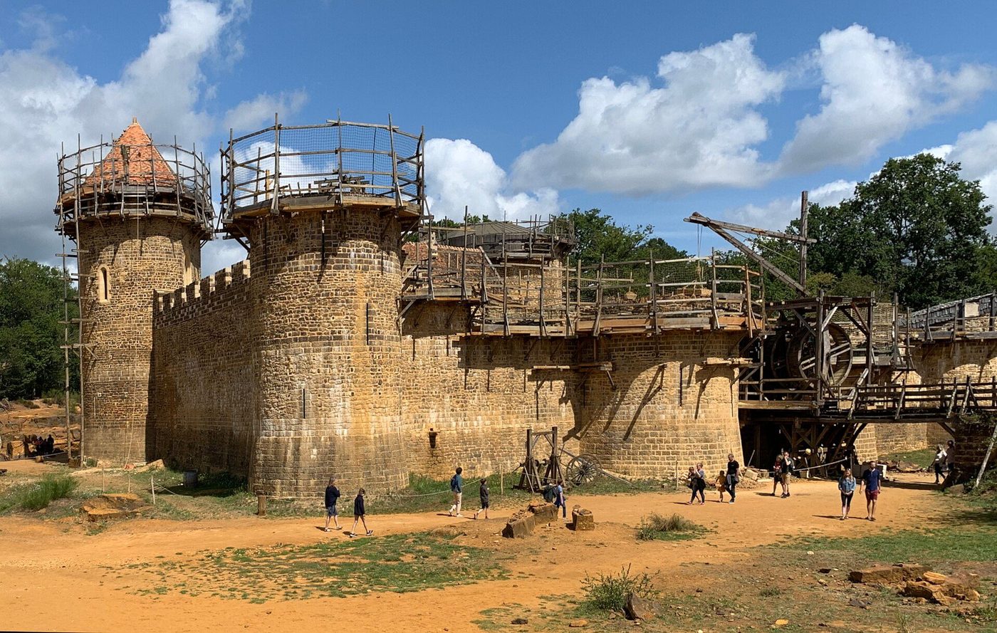 Guédelon Castle under construction: period cranes and timber scaffolding around the rising thirteenth-century walls