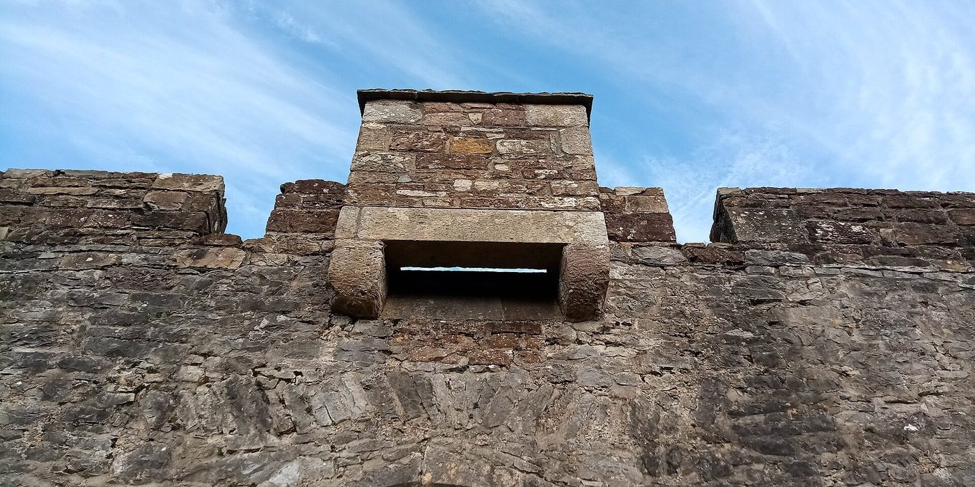 Machicolations at Cahir Castle: the corbelled parapet gallery with open slots in its floor, above a doorway