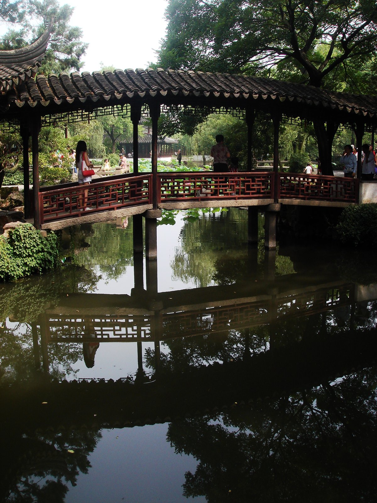A covered zigzag bridge crossing a pond in the Humble Administrator's Garden, Suzhou