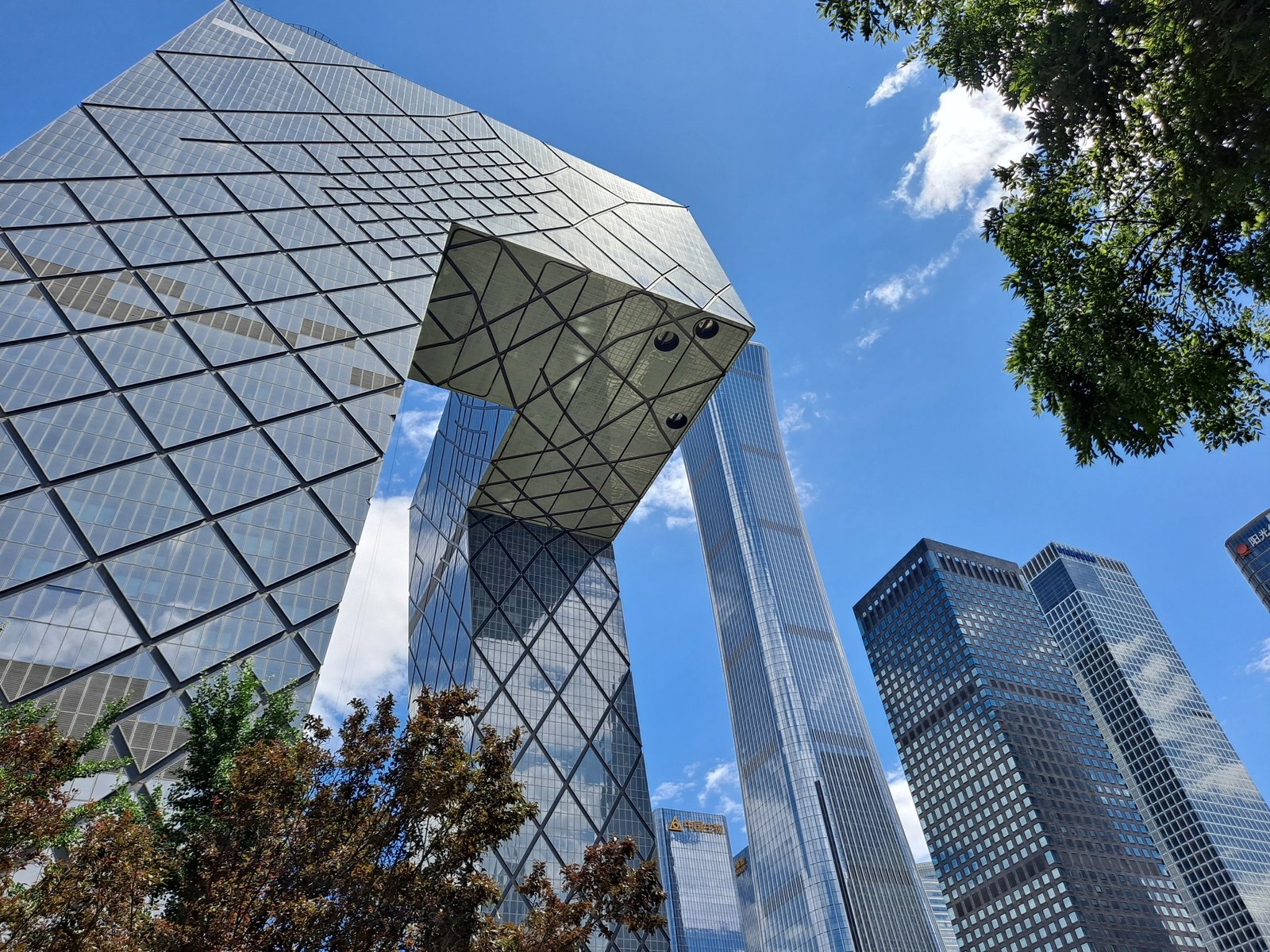 The CCTV Headquarters in Beijing, its two leaning towers joined by a cantilevered loop, seen from below