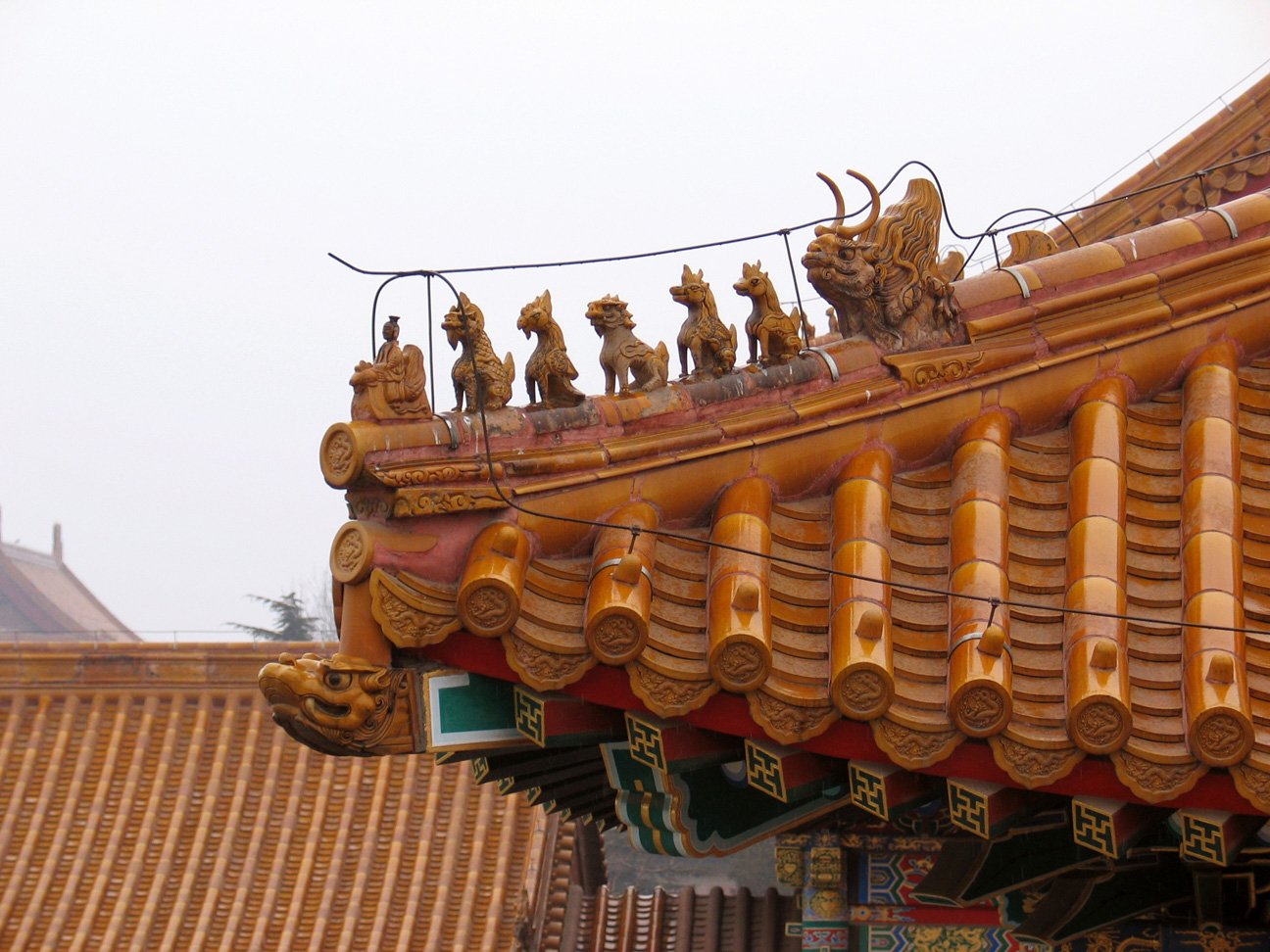 A yellow glazed-tile roof corner in the Forbidden City, with ridge beasts along the ridge