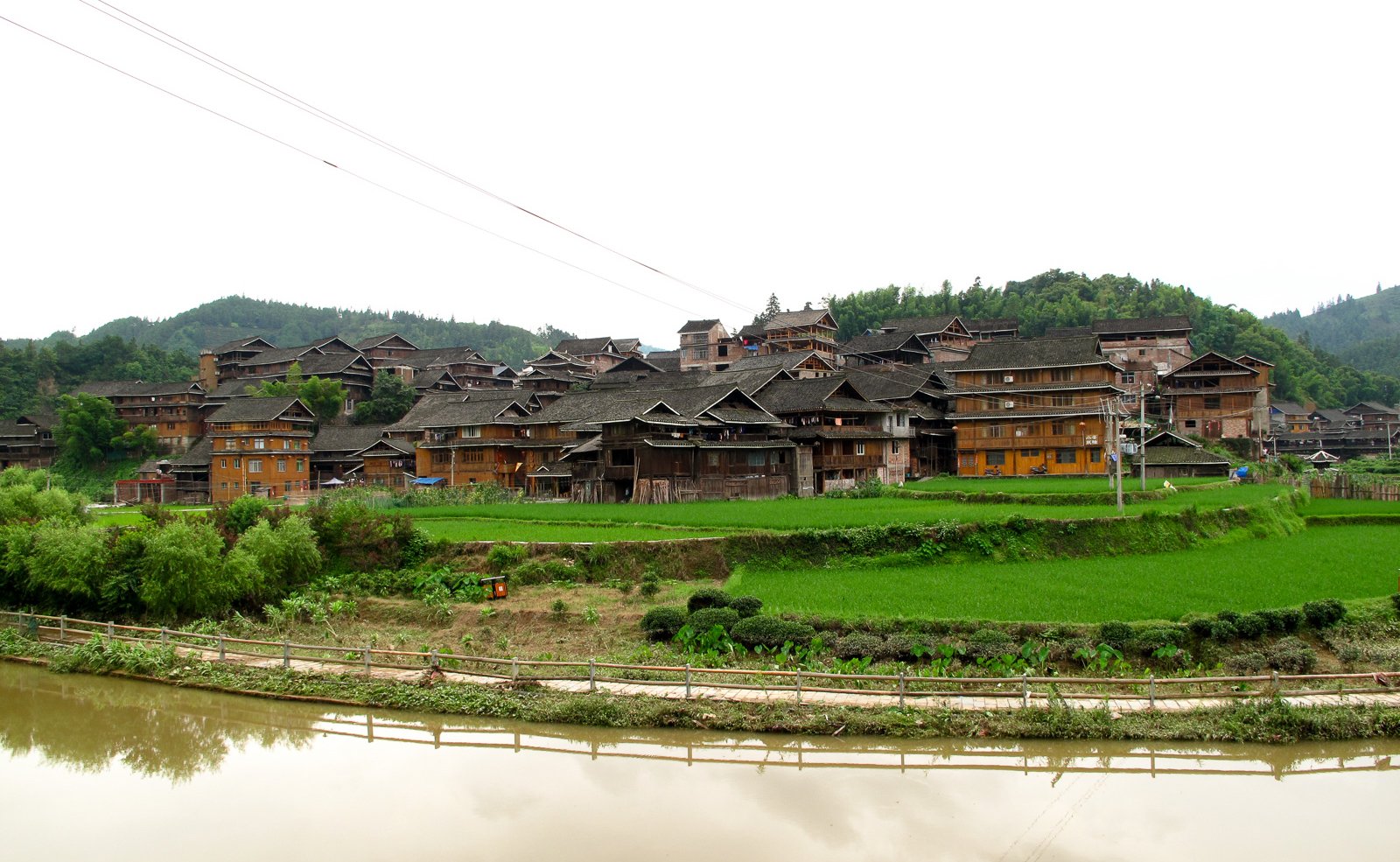 The Dong village of Chengyang, its timber stilt houses clustered above fields beside a river