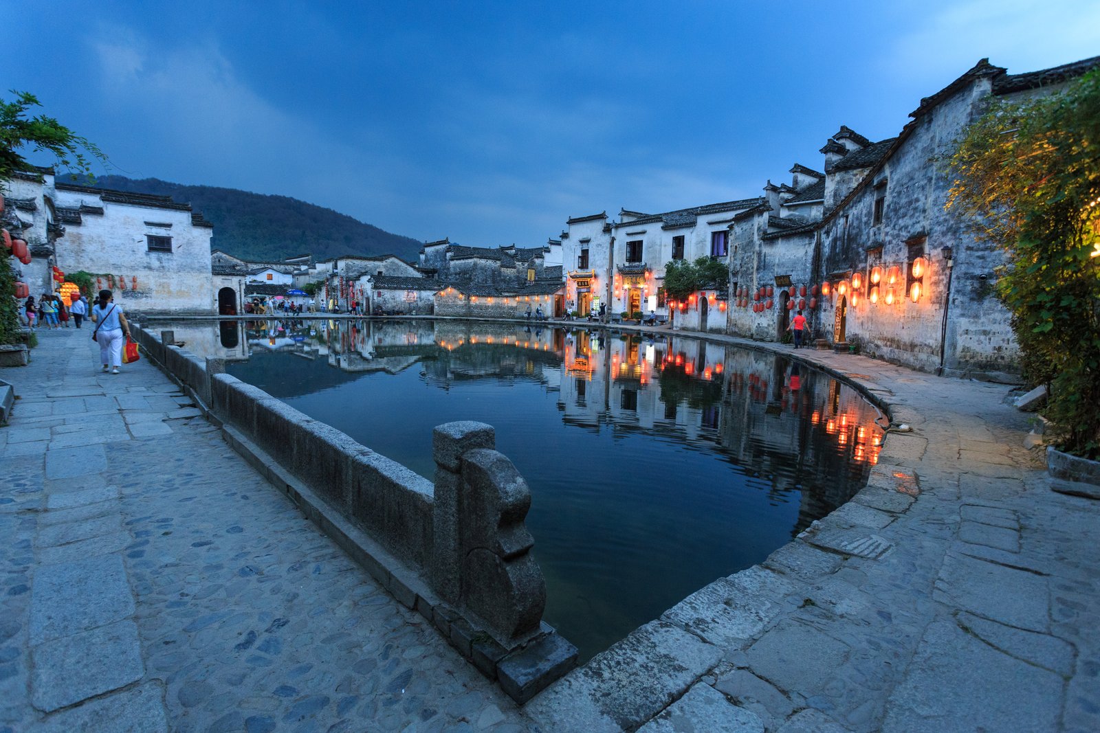 White-walled, black-tiled houses of Hongcun village in Anhui beside a pond at dusk