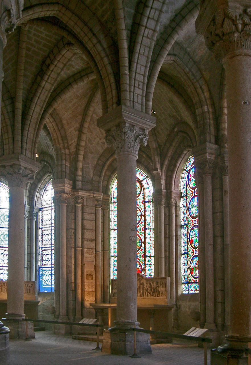 The ambulatory of the Basilica of Saint-Denis: slender monolithic columns, rib vaults and radiating chapel windows of stained glass