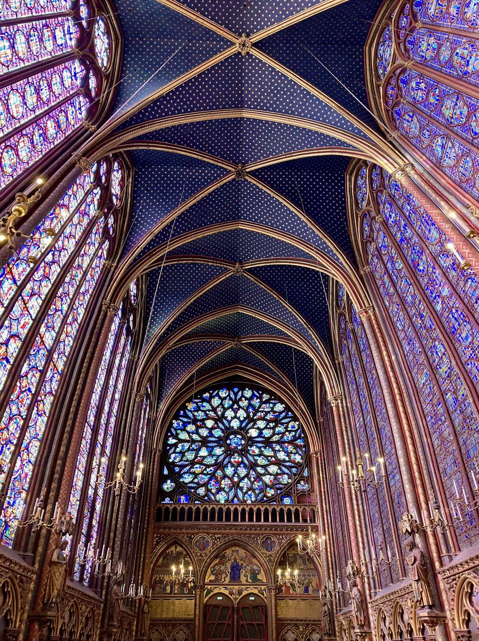 The upper chapel of the Sainte-Chapelle in Paris: walls of stained glass under a painted rib vault and its rose window