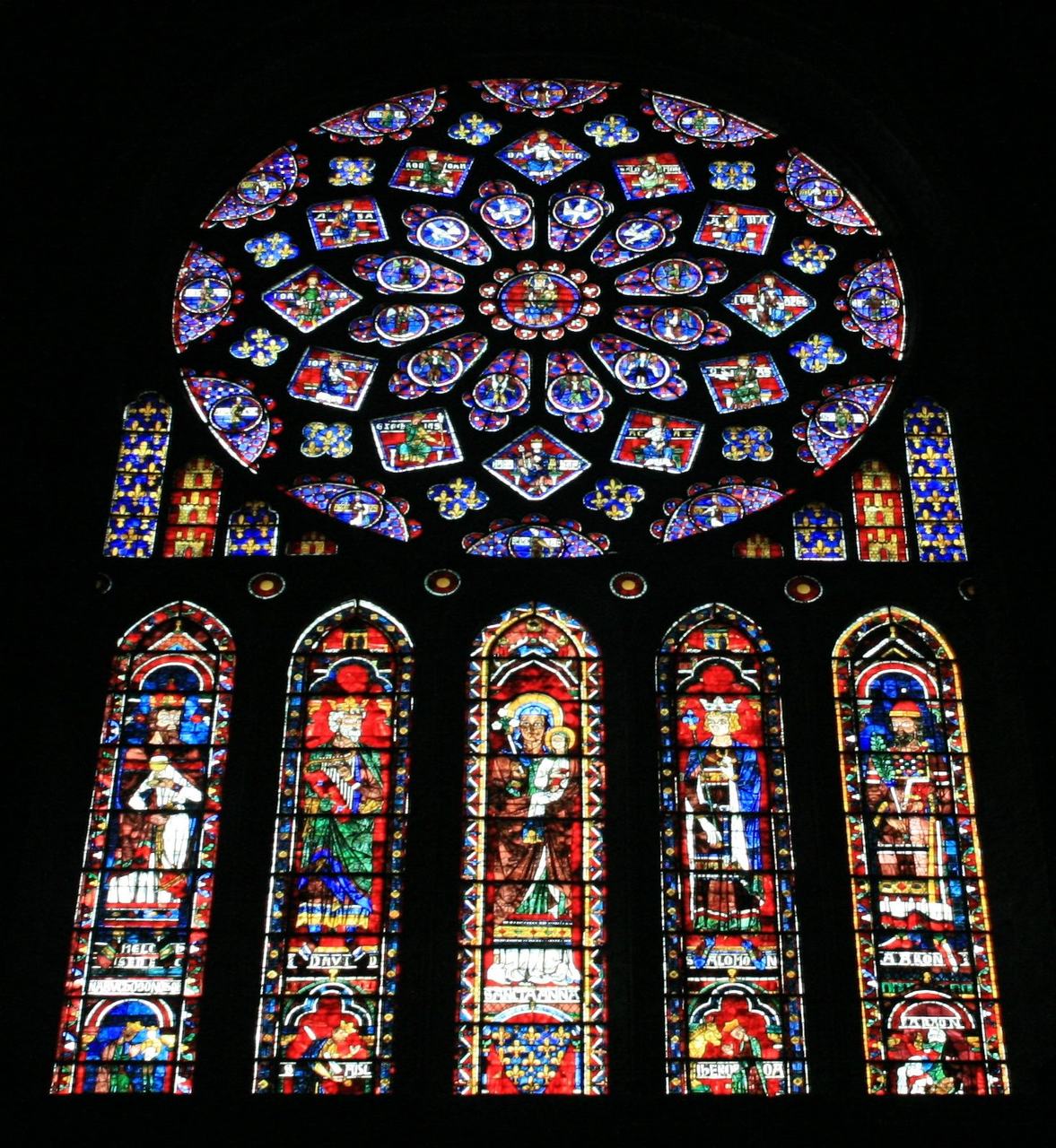 The north rose window of Chartres Cathedral from inside, its lancets filled with kings and prophets in deep blue and red glass