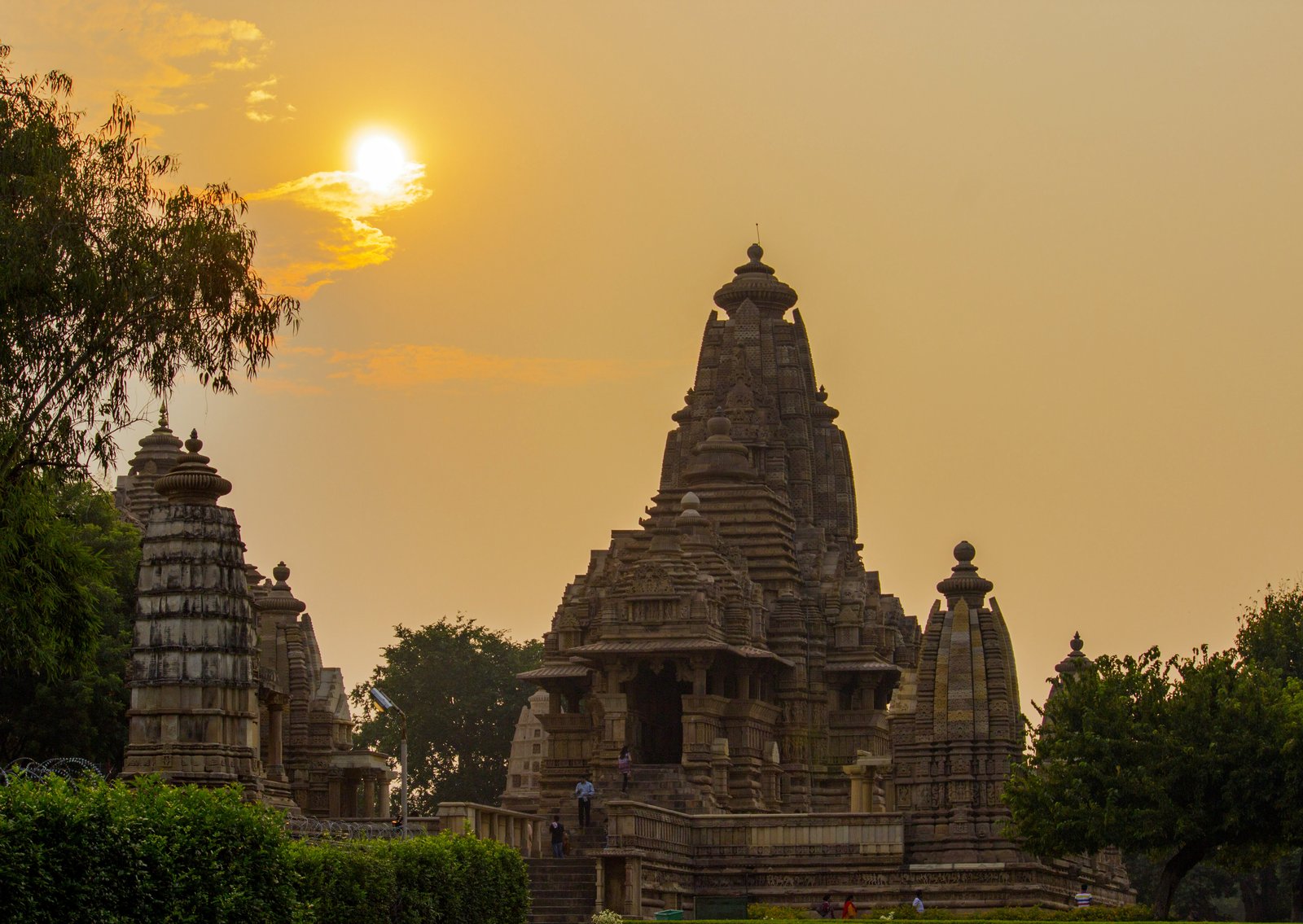 The Kandariya Mahadeva temple at Khajuraho at sunset, its clustered shikharas rising over the platform
