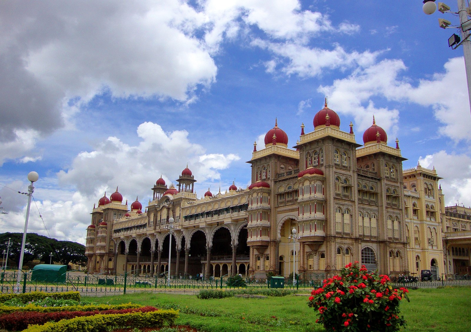 Mysore Palace, its pink domes and arched facade over the gardens