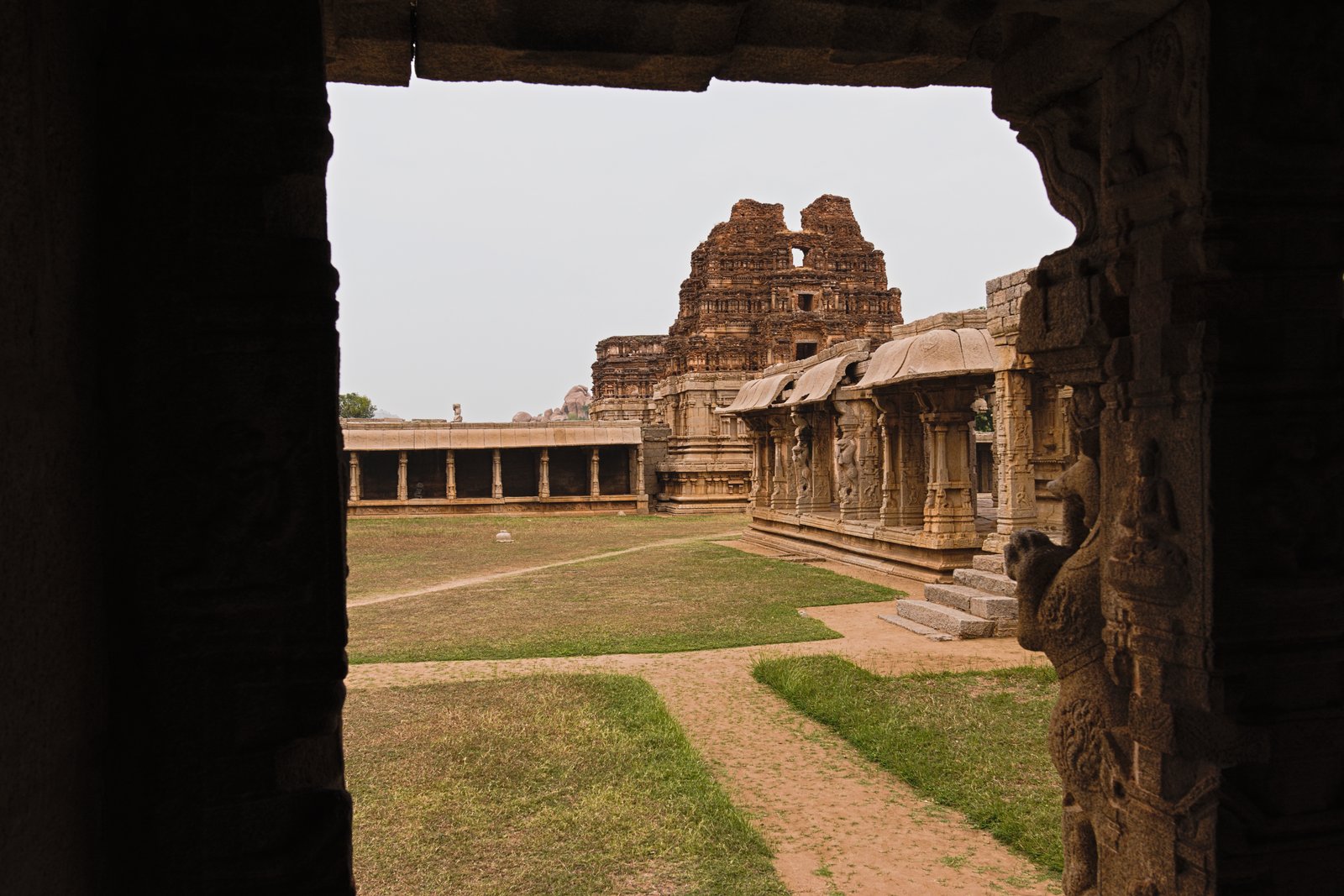 The inner courtyard of the Achyutaraya Temple at Hampi, seen through a dark pillared doorway
