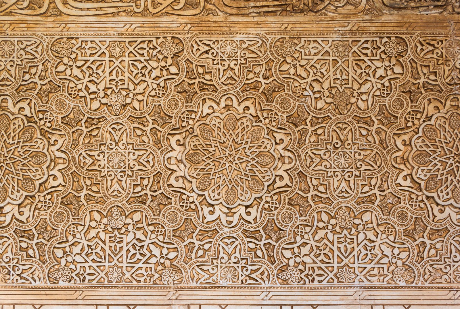 Carved arabesque plaster, its scrolling stems, leaves and flowers