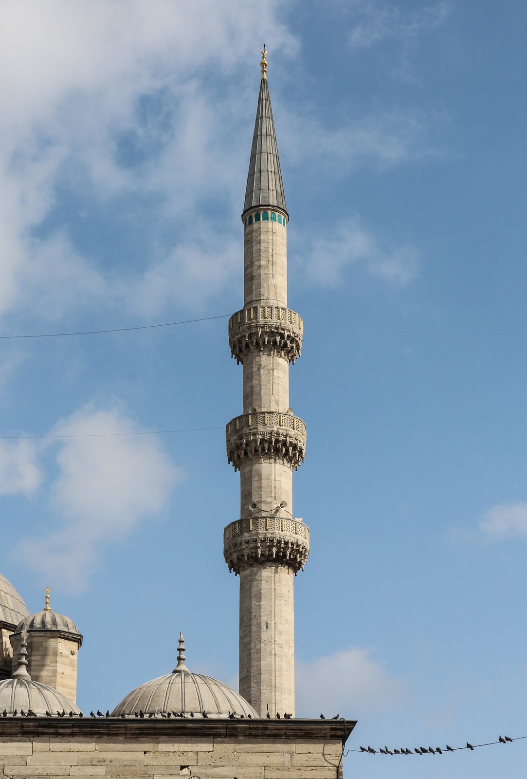 A minaret rising beside a mosque, its balconies marking its form